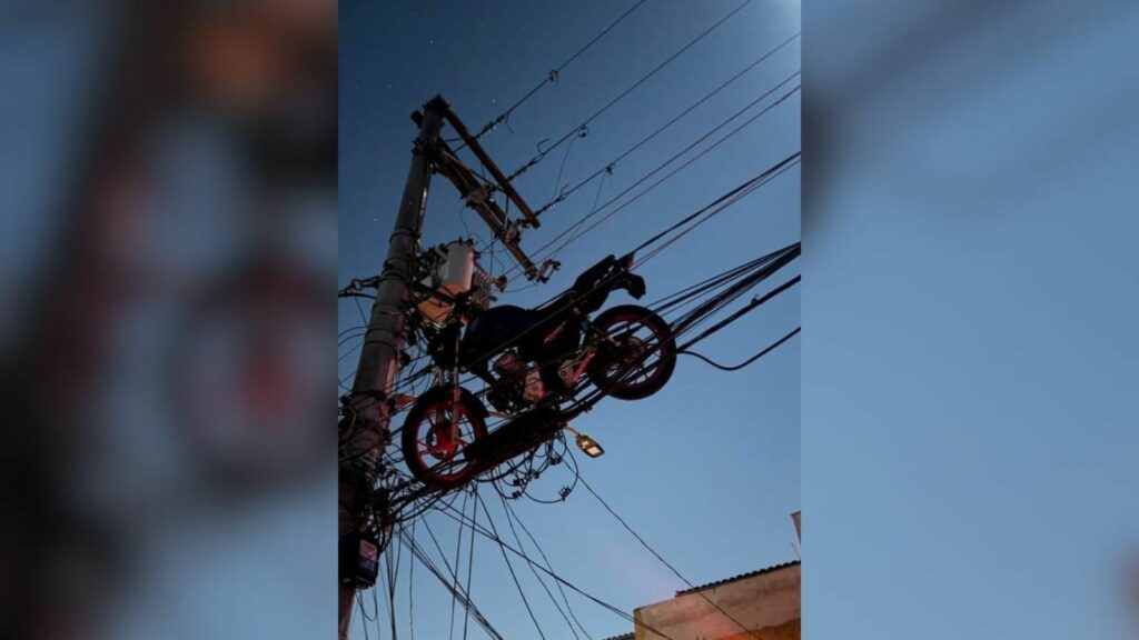 Motocicleta fica presa em fiação elétrica após queda de balão