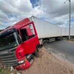 Carreta perde o controle e invade canteiro central no retorno