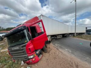 Carreta perde o controle e invade canteiro central no retorno